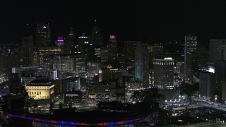 DX0002_193_053 - 5.7K aerial stock footage of the city skyline at night, seen while flying by Comerica Park, Downtown Detroit, Michigan
