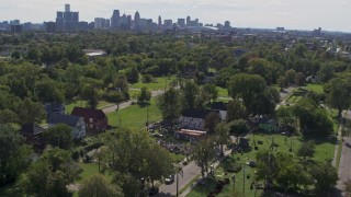DX0002_195_009 - 5.7K aerial stock footage of circling the Heidelberg Project outdoor art display and urban homes, reveal the skyline in Detroit, Michigan