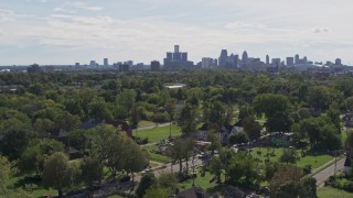 DX0002_195_010 - 5.7K aerial stock footage of the distant skyline seen from the Heidelberg Project outdoor art display and urban homes, Detroit, Michigan