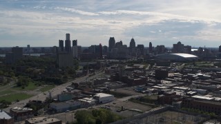DX0002_195_020 - 5.7K aerial stock footage a reverse view of the city's skyline from brick industrial buildings, Downtown Detroit, Michigan