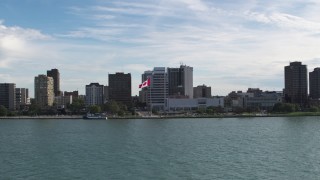 DX0002_196_005 - 5.7K aerial stock footage of approaching office buildings and Canadian flag by the river in Windsor, Ontario, Canada
