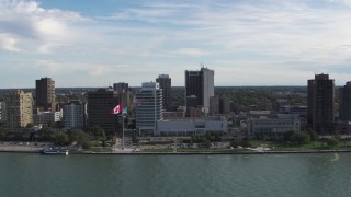 DX0002_196_006 - 5.7K aerial stock footage reverse view of office buildings and Canadian flag by the river in Windsor, Ontario, Canada