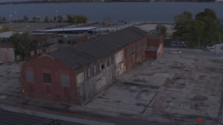 DX0002_197_011 - 5.7K aerial stock footage of an abandoned Northern Cranes factory building at sunset, Detroit, Michigan