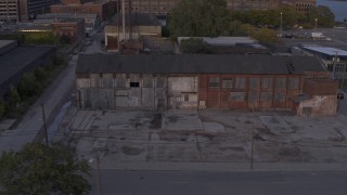 DX0002_197_014 - 5.7K aerial stock footage of circling an abandoned Northern Cranes factory building at sunset, Detroit, Michigan