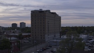 DX0002_197_021 - 5.7K aerial stock footage of descending by an apartment building at sunset, Detroit, Michigan