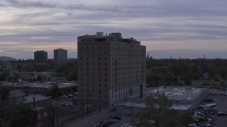 DX0002_197_022 - 5.7K aerial stock footage of ascending by an apartment building at sunset, Detroit, Michigan