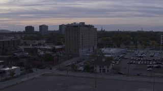 DX0002_197_024 - 5.7K aerial stock footage focus on an apartment building during descent at sunset, Detroit, Michigan