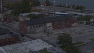 DX0002_197_049 - 5.7K aerial stock footage of orbiting an abandoned brick building at sunset, Detroit, Michigan