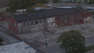 DX0002_197_050 - 5.7K aerial stock footage orbit an abandoned brick building at sunset, Detroit, Michigan