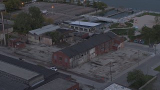 DX0002_197_052 - 5.7K aerial stock footage flying away from an abandoned brick building at sunset, Detroit, Michigan