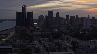 DX0002_198_005 - 5.7K aerial stock footage of flying away from and by the city's towering skyscrapers at sunset, Downtown Detroit, Michigan