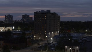 DX0002_198_022 - 5.7K aerial stock footage orbit an apartment building at twilight, Detroit, Michigan