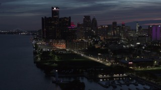 DX0002_198_030 - 5.7K aerial stock footage of the city's skyline, seen while flying over the river at twilight in Downtown Detroit, Michigan