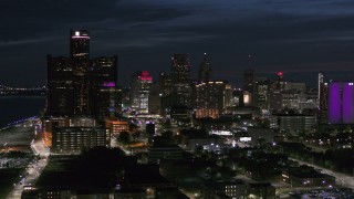 DX0002_198_032 - 5.7K aerial stock footage of ascending toward the brightly lit city skyline at twilight in Downtown Detroit, Michigan