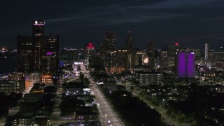 DX0002_198_033 - 5.7K aerial stock footage of the brightly lit city skyline at night seen from Jefferson Ave in Downtown Detroit, Michigan