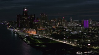 DX0002_198_037 - 5.7K aerial stock footage of the brightly lit skyscrapers in the city skyline at night, Downtown Detroit, Michigan