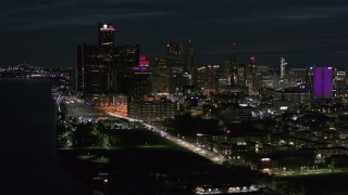 DX0002_198_038 - 5.7K aerial stock footage of the brightly lit skyscrapers in the city skyline at night, seen from the river, Downtown Detroit, Michigan