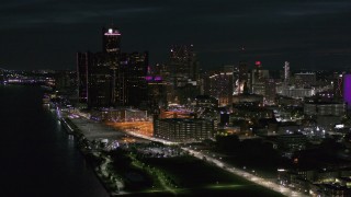 DX0002_198_044 - 5.7K aerial stock footage approach and flyby GM Renaissance Center and skyscrapers from river at night, Downtown Detroit, Michigan