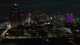 DX0002_198_047 - 5.7K aerial stock footage focus on the skyline during ascent at night, Downtown Detroit, Michigan