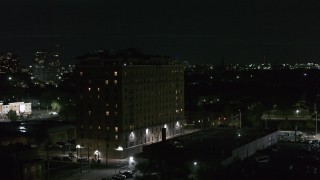 DX0002_198_059 - 5.7K aerial stock footage of an orbit of an apartment building at night, Detroit, Michigan