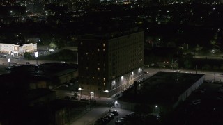 DX0002_198_061 - 5.7K aerial stock footage focus on an apartment building while ascending at night, Detroit, Michigan
