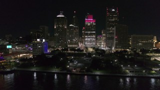 DX0002_199_011 - 5.7K aerial stock footage orbit and fly away from Hart Plaza and towering skyscrapers at night, Downtown Detroit, Michigan