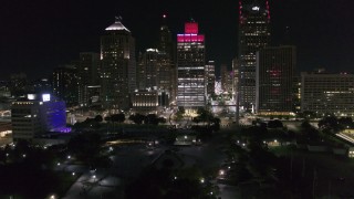 DX0002_199_014 - 5.7K aerial stock footage fly over river and Hart Plaza toward towering skyscrapers at night, Downtown Detroit, Michigan