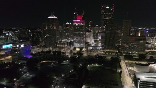 DX0002_199_016 - 5.7K aerial stock footage a reverse view of Hart Plaza and towering skyscrapers at night, Downtown Detroit, Michigan