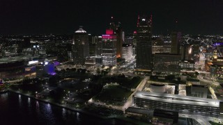 DX0002_199_021 - 5.7K aerial stock footage of orbiting Hart Plaza by tall skyscrapers at night, seen from the river, Downtown Detroit, Michigan