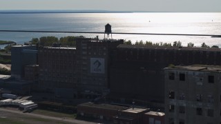 DX0002_201_037 - 5.7K aerial stock footage of orbiting a water tower on a flour mill in Buffalo, New York