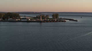 DX0002_204_019 - 5.7K aerial stock footage ascend away from Lake Erie lighthouse at sunset, Buffalo, New York