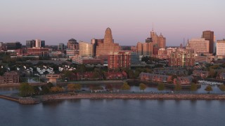 DX0002_204_024 - 5.7K aerial stock footage of city hall and office buildings at sunset, seen from waterfront condos, Downtown Buffalo, New York