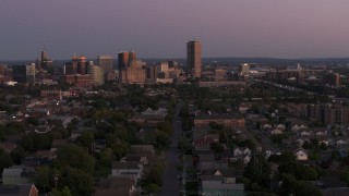 DX0002_204_035 - 5.7K aerial stock footage of Seneca One Tower and the city's skyline while passing homes at twilight, Downtown Buffalo, New York