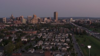 DX0002_204_036 - 5.7K aerial stock footage of Seneca One Tower and skyline seen while passing homes at twilight, Downtown Buffalo, New York