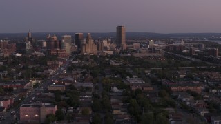 DX0002_204_037 - 5.7K aerial stock footage of Seneca One Tower and skyline seen while descending past homes at twilight, Downtown Buffalo, New York