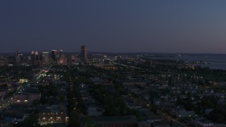DX0002_204_047 - 5.7K aerial stock footage of skyscraper seen from I-190 and homes at twilight, Downtown Buffalo, New York