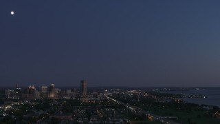 DX0002_204_048 - 5.7K aerial stock footage of the moon high above the city's skyline at twilight, Downtown Buffalo, New York