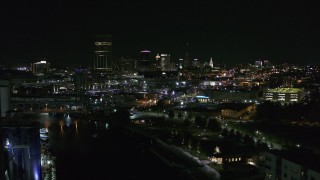 DX0002_205_017 - 5.7K aerial stock footage of flying past the downtown skyline at night, reveal grain elevators, Downtown Buffalo, New York