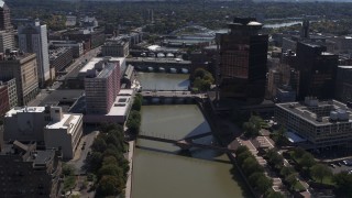 DX0002_206_011 - 5.7K aerial stock footage fly away from riverfront hotel across Genessee River from office building, Downtown Rochester, New York