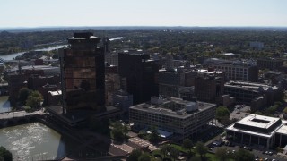 DX0002_206_014 - 5.7K aerial stock footage descend with view of office buildings and hotel by the Genessee River, Downtown Rochester, New York