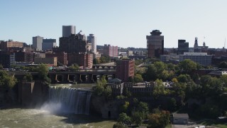 DX0002_206_034 - 5.7K aerial stock footage slowly approach falls and river bridges near skyline, Downtown Rochester, New York