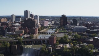 DX0002_206_040 - 5.7K aerial stock footage of flying over High Falls toward Genesee River bridges and skyline, Downtown Rochester, New York