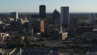 DX0002_209_002 - 5.7K aerial stock footage ascend and orbit apartment building near high-rises, Downtown Rochester, New York
