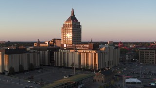 DX0002_209_040 - 5.7K aerial stock footage descend away from Kodak Tower and a college at sunset, Rochester, New York