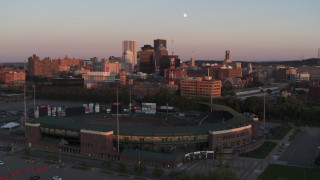 DX0002_209_045 - 5.7K aerial stock footage ascend by baseball stadium to approach radio tower at sunset, Downtown Rochester, New York