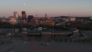 DX0002_209_046 - 5.7K aerial stock footage fly away from office buildings and radio tower at sunset, reveal stadium, Downtown Rochester, New York