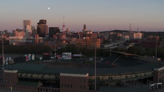 DX0002_209_048 - 5.7K aerial stock footage fly over baseball stadium to approach radio tower and office buildings at sunset, Downtown Rochester, New York
