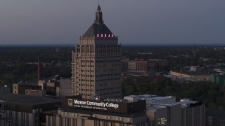 DX0002_210_010 - 5.7K aerial stock footage descend while focused on the top of Kodak Tower at twilight, Rochester, New York