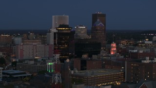 DX0002_210_018 - 5.7K aerial stock footage descend and orbit the city skyline behind radio tower, First Federal Plaza at twilight, Downtown Rochester, New York