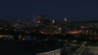 DX0002_210_026 - 5.7K aerial stock footage reverse view of office buildings, reveal stadium at night, Downtown Rochester, New York
